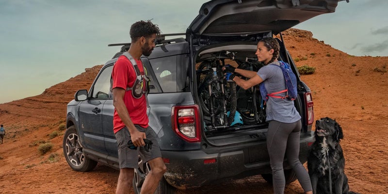 People taking out gear from the trunk of a Bronco Sport.