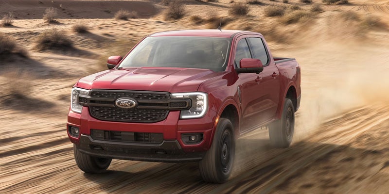 Red 2026 Ford Ranger driving through desert road